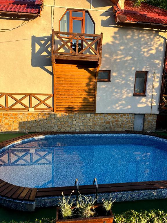 a swimming pool in front of a house at Готель in Yaremche