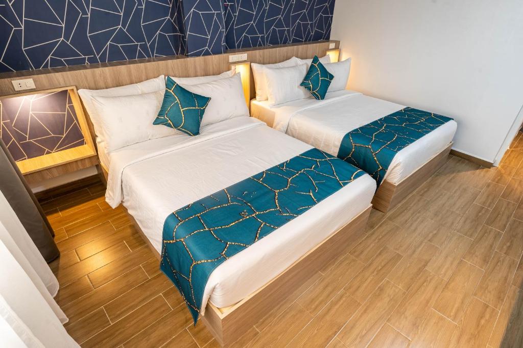 two beds in a room with blue and white at Kuadro Hotel & Suites in Moalboal
