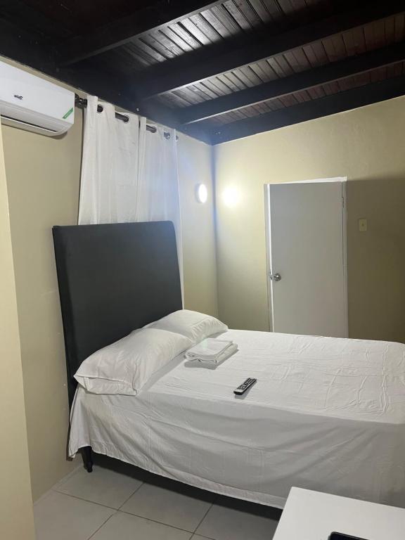 a bedroom with a white bed with a mirror at Manor Villas in Kingston