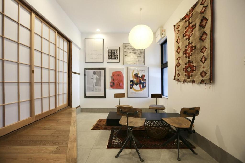 a hallway with a table and chairs in a room at Kamin Kanazawa in Kanazawa