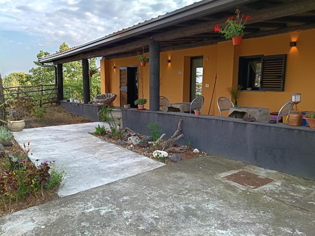 a yellow house with a porch and a patio at Etna Country Home in Nicolosi