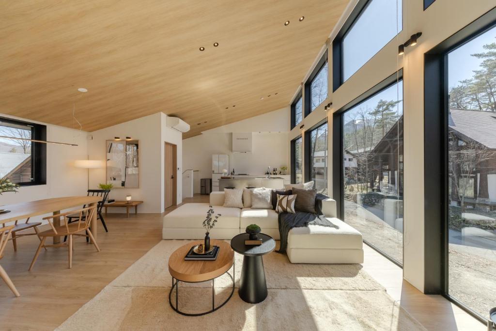 a living room and dining room with large windows at Kuro Hakuba in Hakuba
