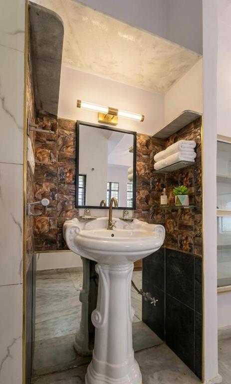 a bathroom with a sink and a mirror at Hardik villa in Udaipur