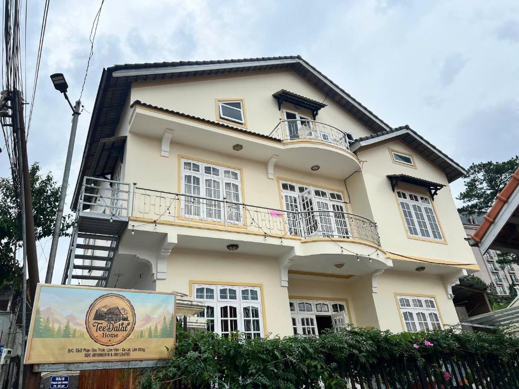 a yellow building with a sign in front of it at TeeDalat House in Khu Chi Lăng