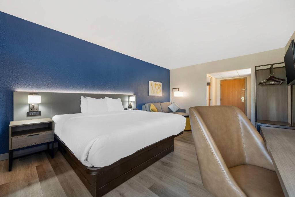 a bedroom with a large white bed and a blue wall at Comfort Inn West Hazleton in West Hazleton
