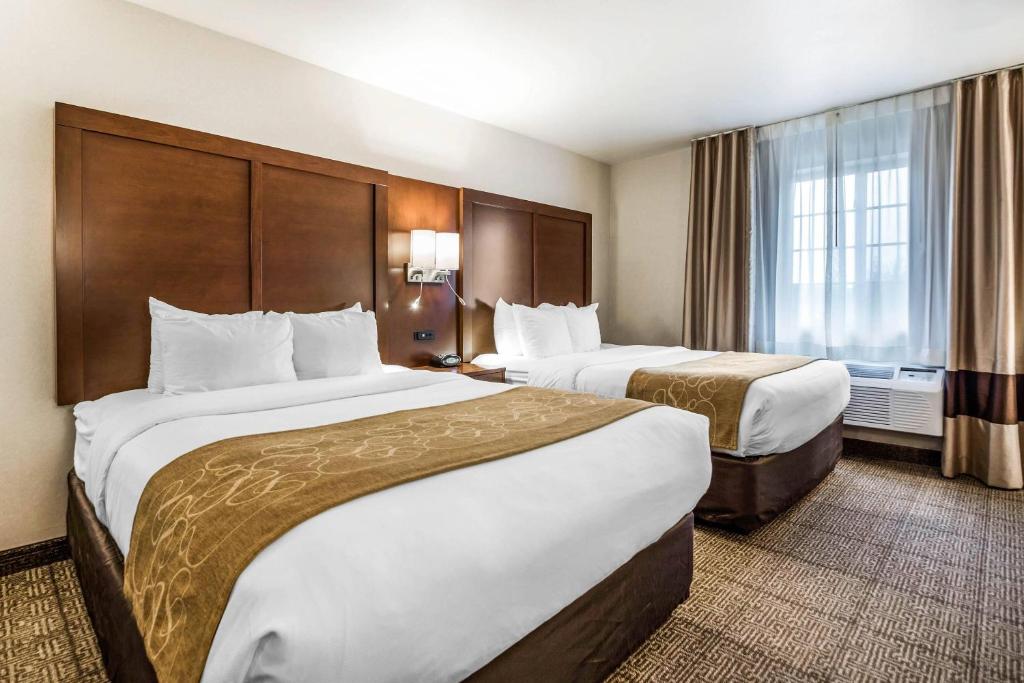 a hotel room with two beds and a window at Comfort Suites at Par 4 Resort in Waupaca