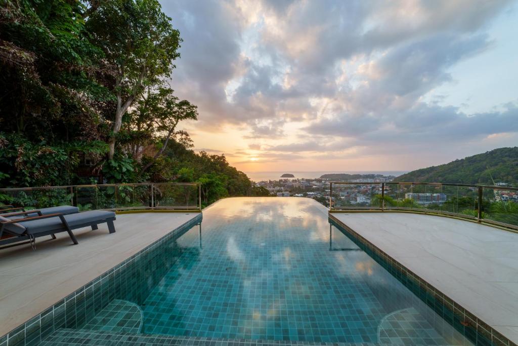a swimming pool on top of a building with a sunset at Villa 18 Kata-Private Pool Villa with Sea View in Ban Kata