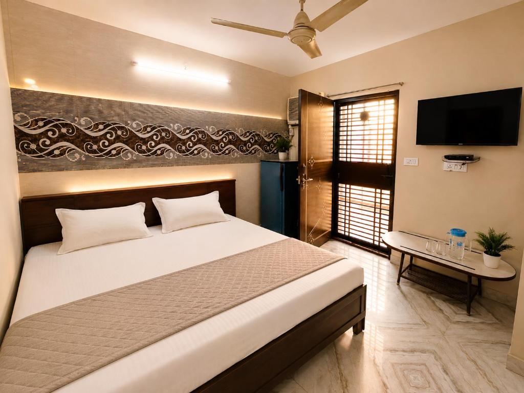 a bedroom with a bed and a flat screen tv at AMAN RESIDENCY in New Delhi