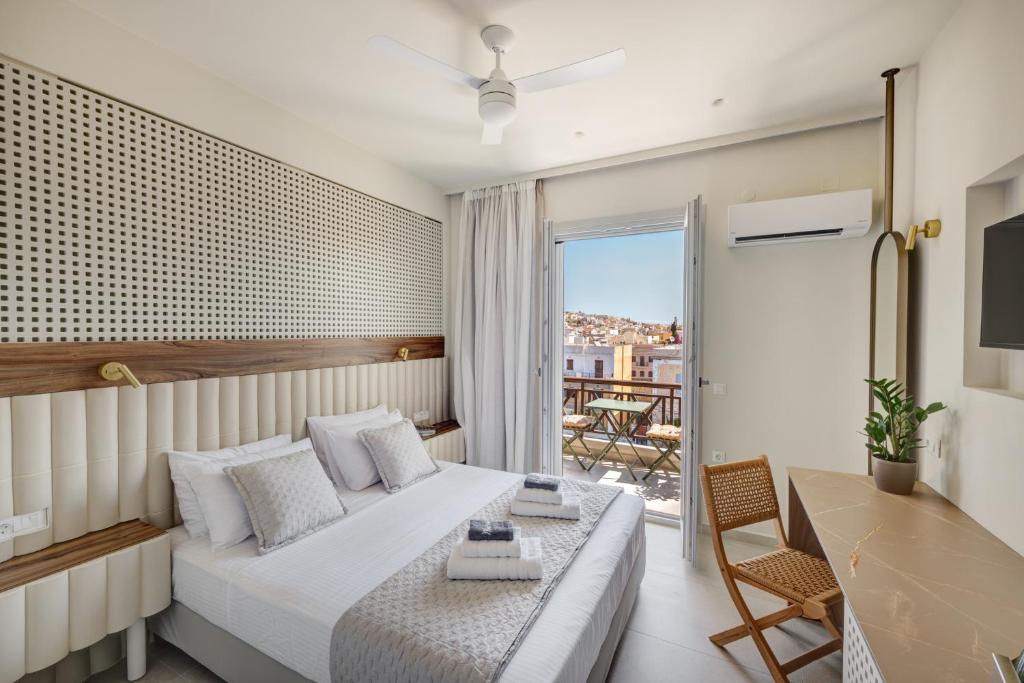 a hotel room with a bed and a balcony at Arxontissa Rooms in Ermoupoli