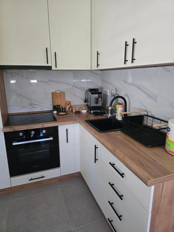 a kitchen with white cabinets and a sink and a stove at Green Diamond in Vrnjci