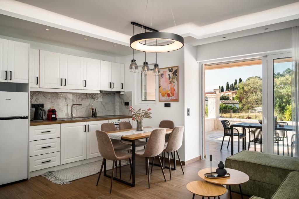 a kitchen and living room with a table and chairs at Lumino Suites Corfu in Corfu
