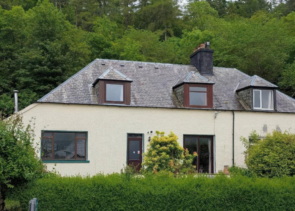 a white house with a gray roof and windows at Callart View in Ballachulish