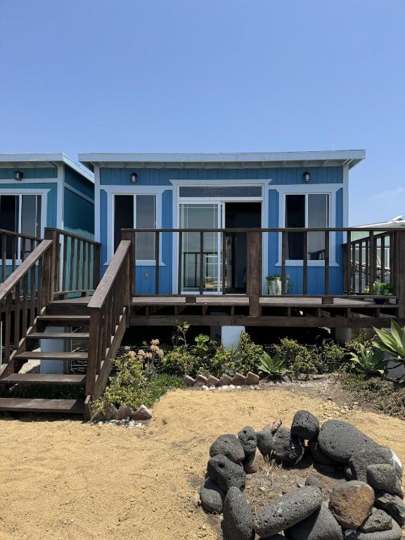 a blue house on the beach with a pile of rocks at Campo Rivera Beach Community in La Misión