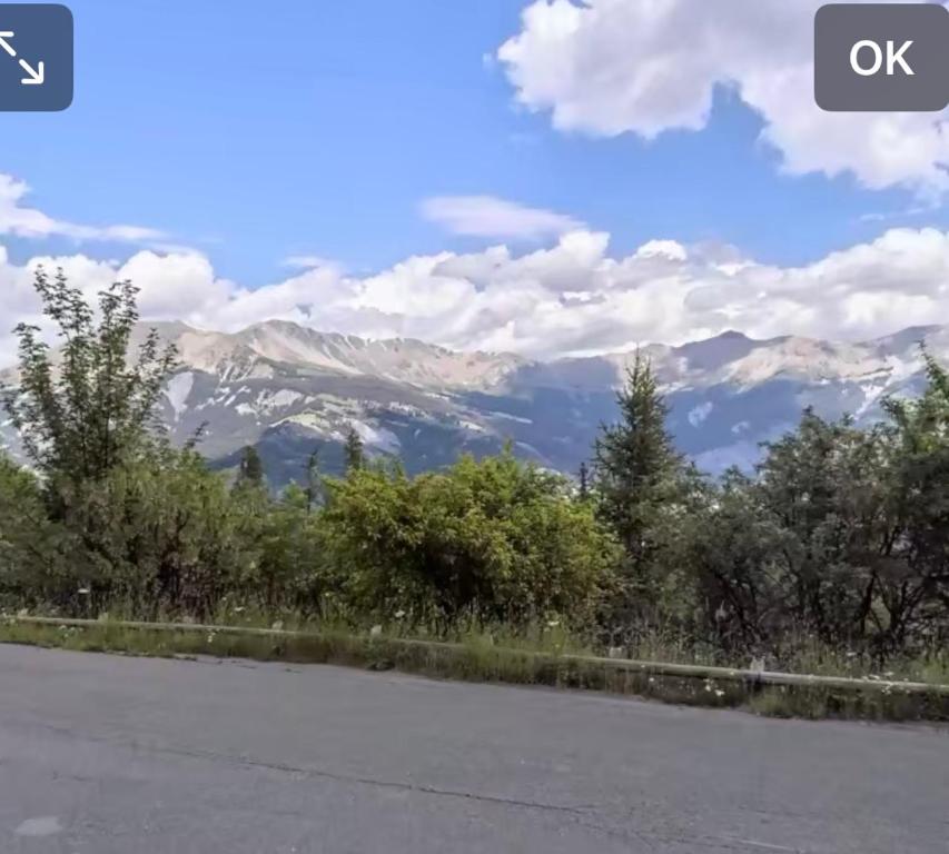 an empty road with mountains in the background at Appartement praloup 1600 in Pra-Loup