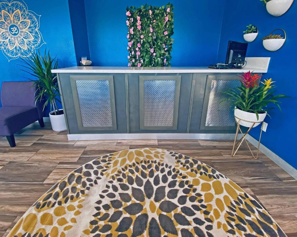 a living room with a blue wall with plants at Rodeway Inn Old Town Scottsdale in Scottsdale