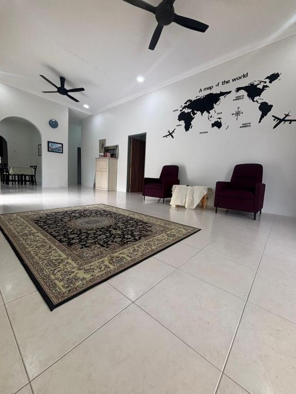 a living room with a map of the world on the wall at Damai Ria INAP DESA in Jerantut