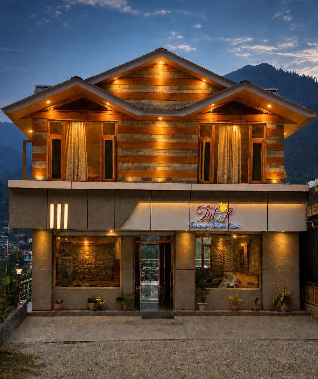 a building with a sign in front of it at Tulip Flowing River View Hotel. in Shamshi