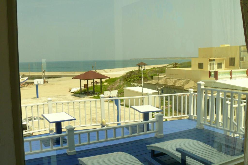 a balcony with chairs and a view of a beach at Sunrise B&amp;B in Huxi