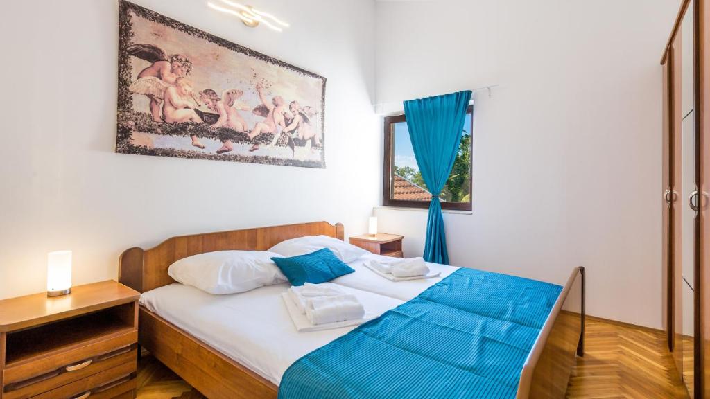 a bedroom with a bed and a painting on the wall at Vila Iris - Opatija by Villas Guide in Breza