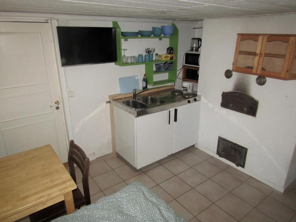 a small kitchen with a sink and a table at Sundqvistens basement in Emkarby