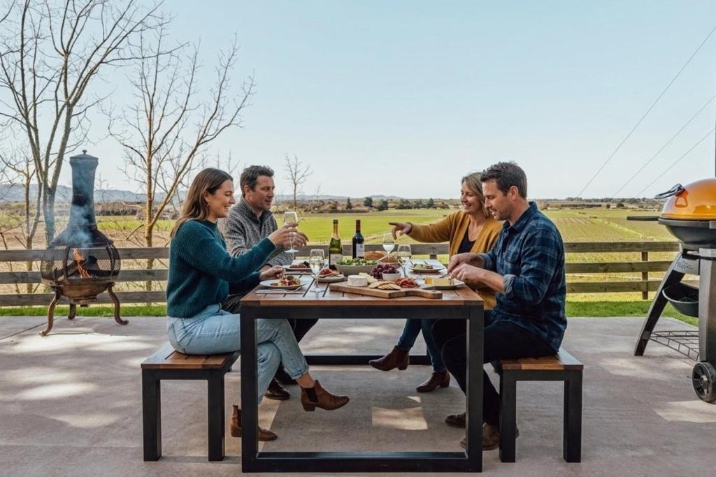 a group of people sitting at a table drinking wine at Black Label Retreats in Gisborne