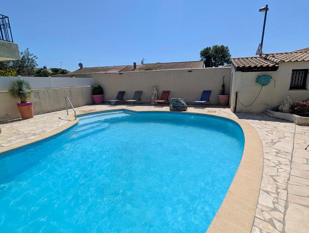 a large blue swimming pool in a yard at Le Jasmin in Mauguio