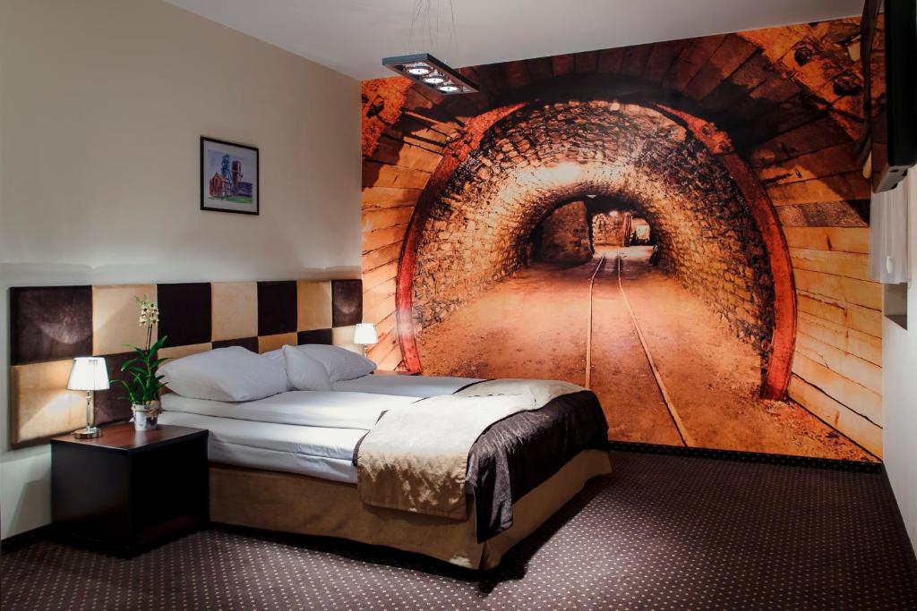 ビトムにあるBoutique Hotel's Bytomのトンネル壁画付きのベッドルーム