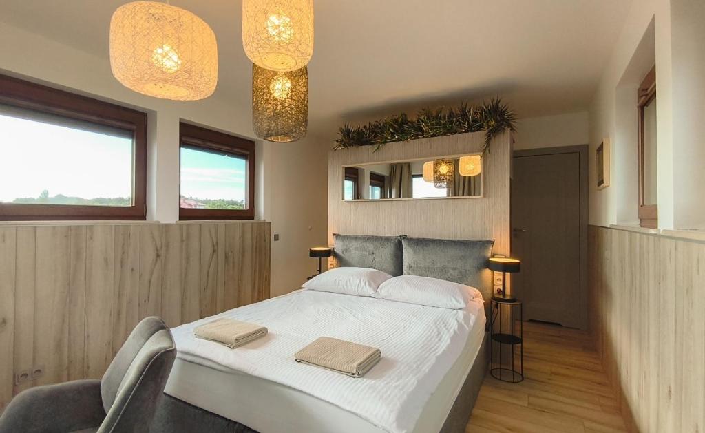 a bedroom with a large bed with two towels on it at Pensjonat Kotwica in Kuźnica