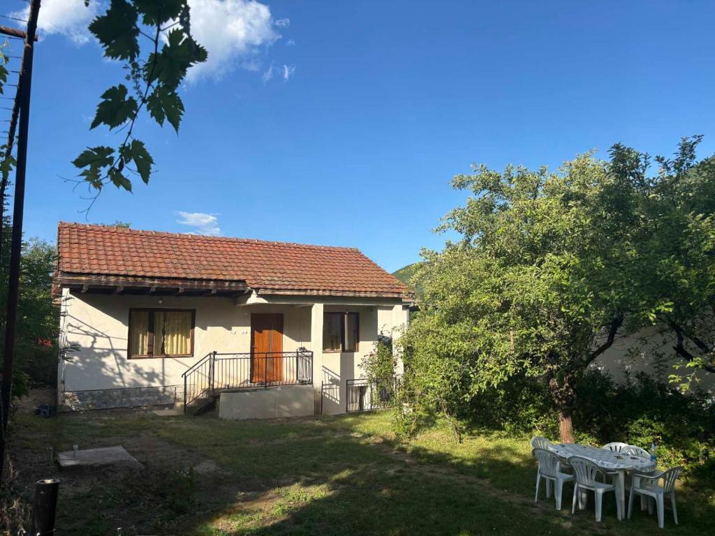 a house with a table and chairs in the yard at EmiliJana House in Dolna Matka