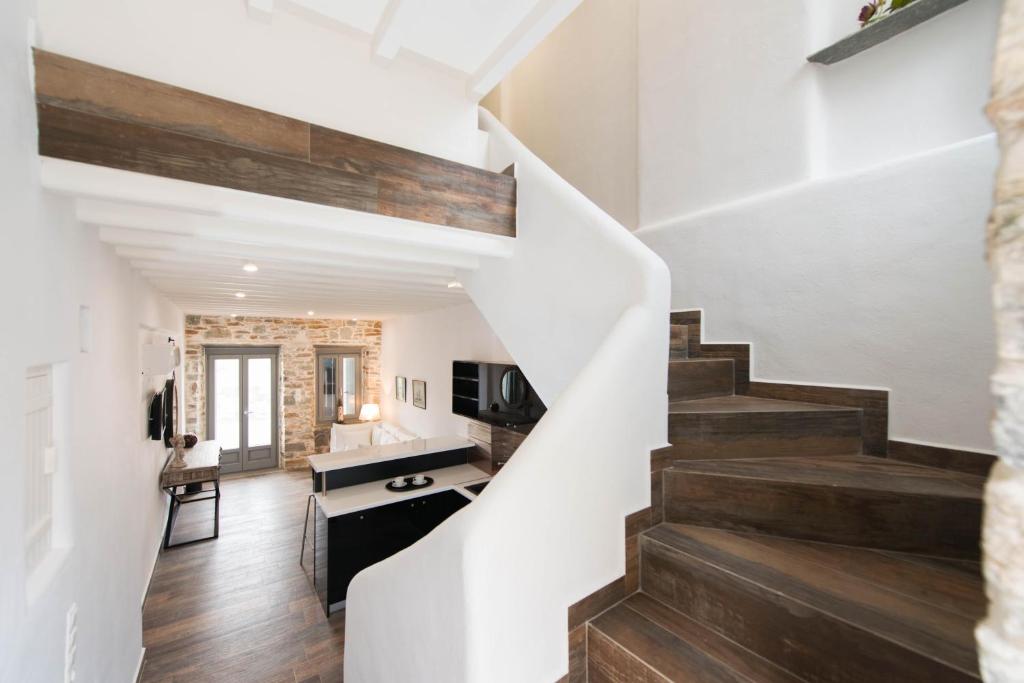 a staircase leading up to a living room and dining room at Athina Exquisite Houses in Kastron