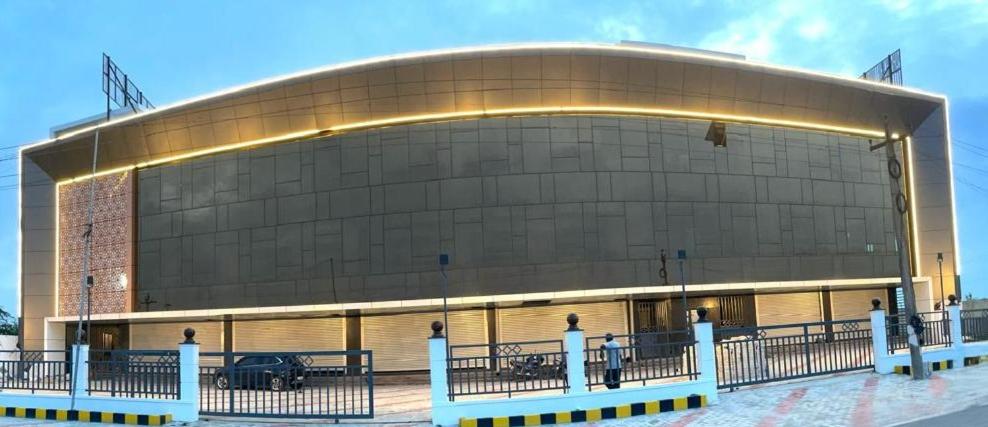 a large building with a bench in front of it at SSR PARADISE ROOMs in Kavarapettai