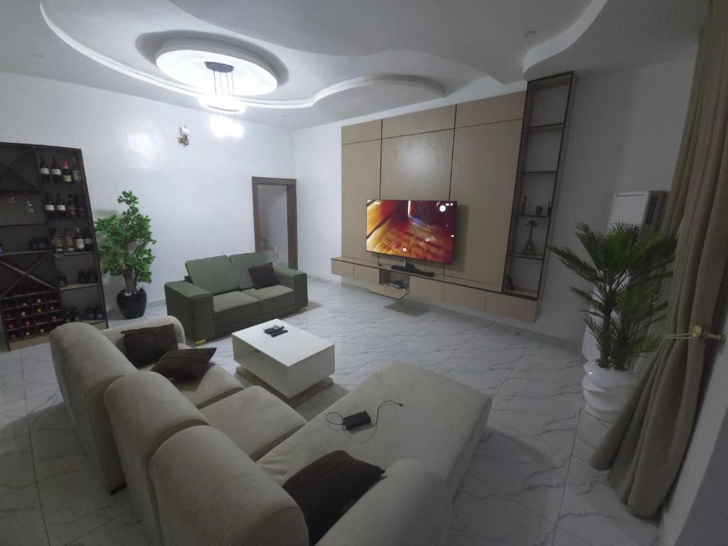 a living room with a couch and a tv at House 27 Crown in Idu
