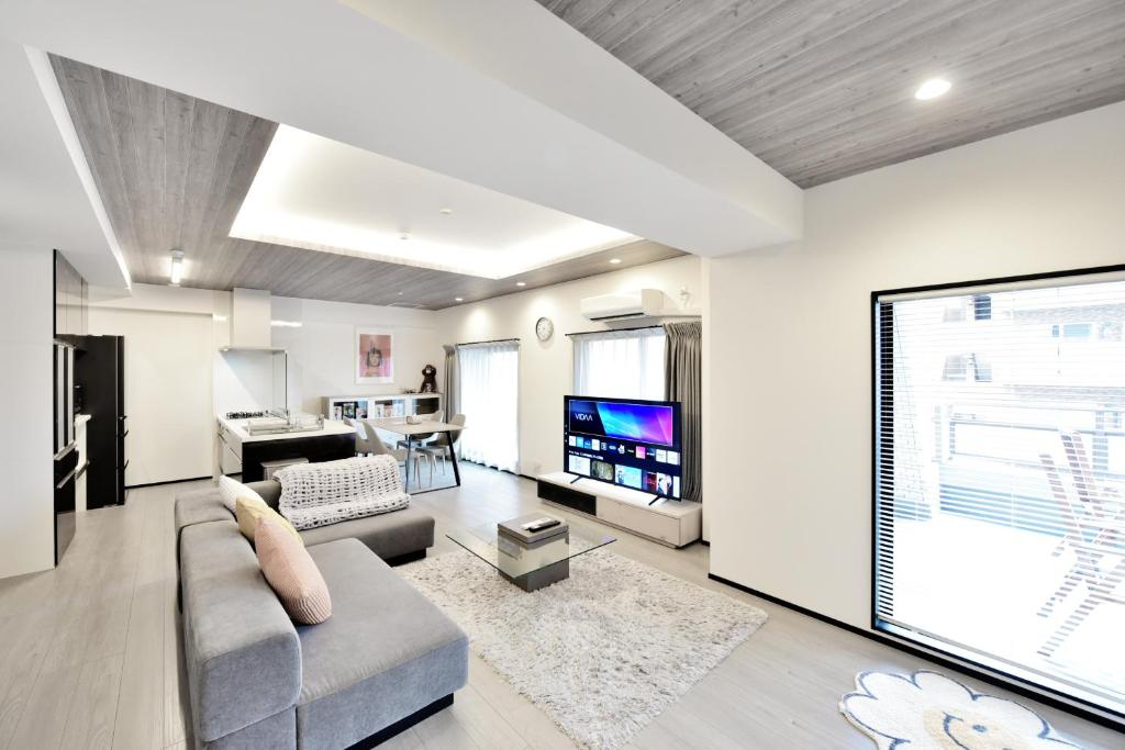 a living room with a couch and a tv at Room 701 Large 3LDK 98sqm Near Namba Big Balcony Ideal for Groups and Long Stay in Osaka