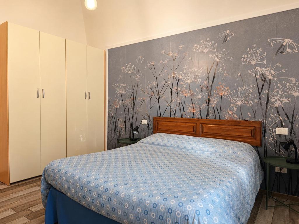 a bedroom with a bed with a blue comforter at B&B Interno SG in LʼAquila
