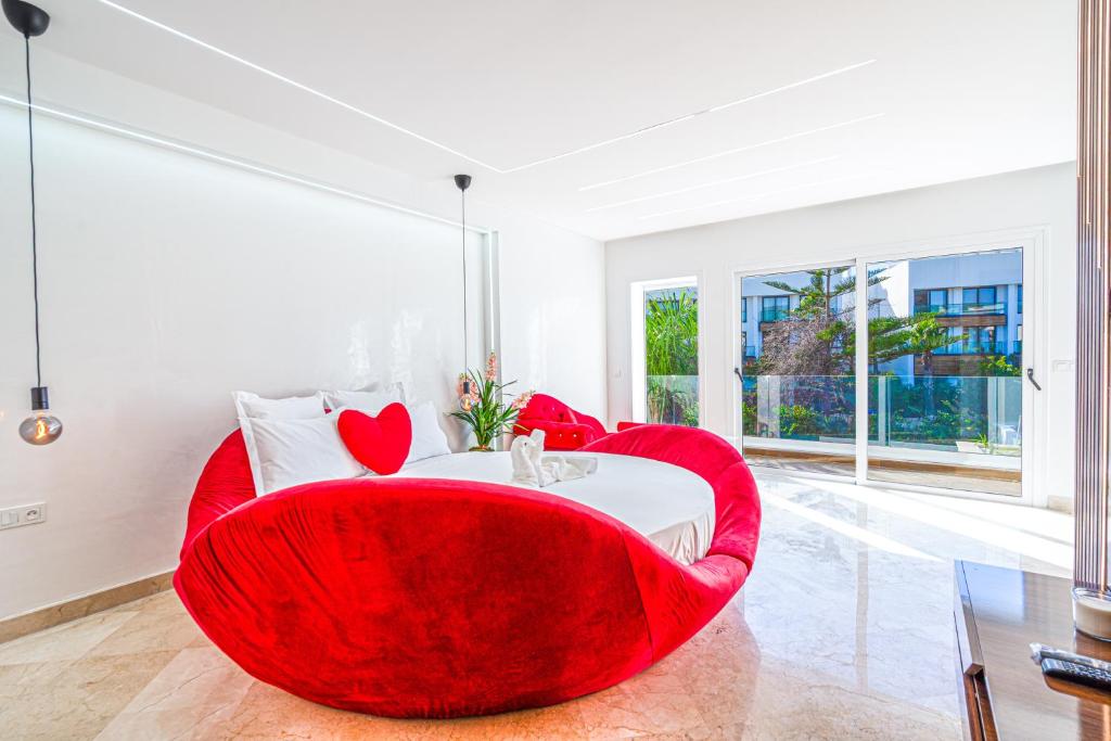 a living room with a red chair and a table at Villa 33 Ultra Lux High-End in Tangier