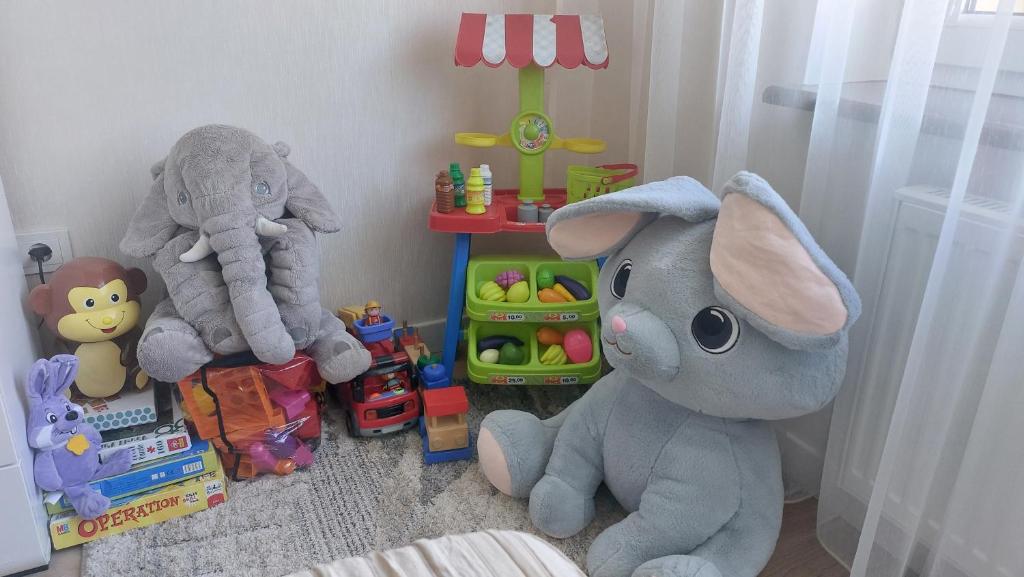two stuffed elephants and other toys in a childs room at Apartamentai Gertrūda in Druskininkai