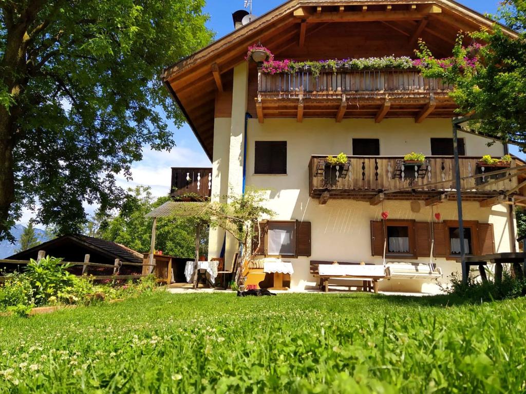 a house with a balcony with a bench in the yard at Rienznerhof Natureplace in Montagna