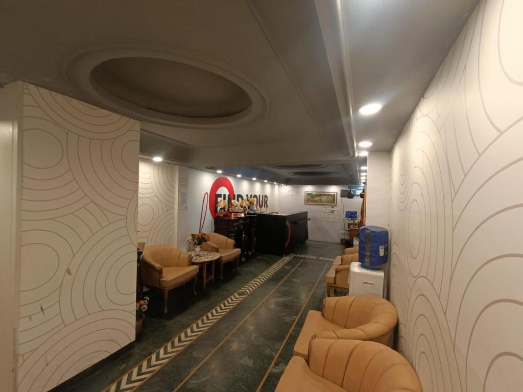 a living room with couches and a table and chairs at Hotel Mount View in Shimla