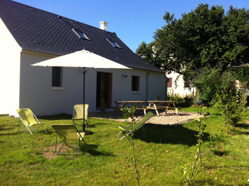 a yard with a table and chairs and an umbrella at chateaugite in Pontlevoy
