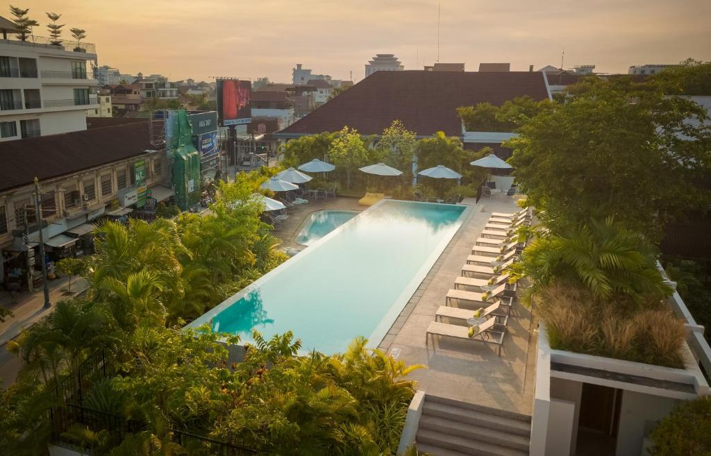 an overhead view of a swimming pool with umbrellas at The Aviary Hotel in Siem Reap