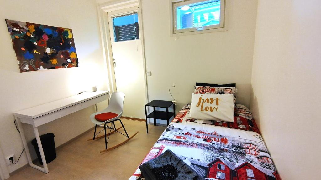 a small bedroom with a bed and a desk at City & Forest Relax Room with Private Sauna & Garden in Espoo