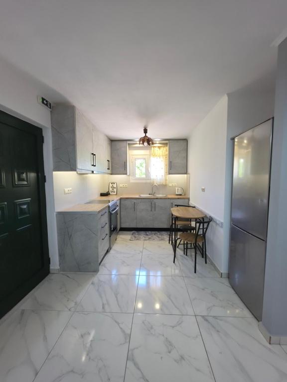 a large kitchen with a table and a counter top at Garyfallia's House in Korifásion