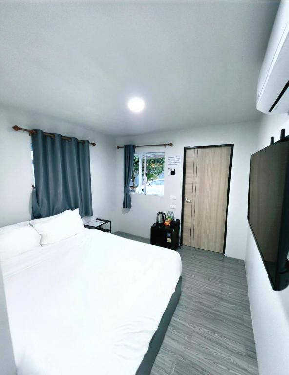 a bedroom with a white bed and a flat screen tv at Cloud Bed Ao Nang- High Speed internet, Comfort bed , Smart Tv in Ao Nang Beach