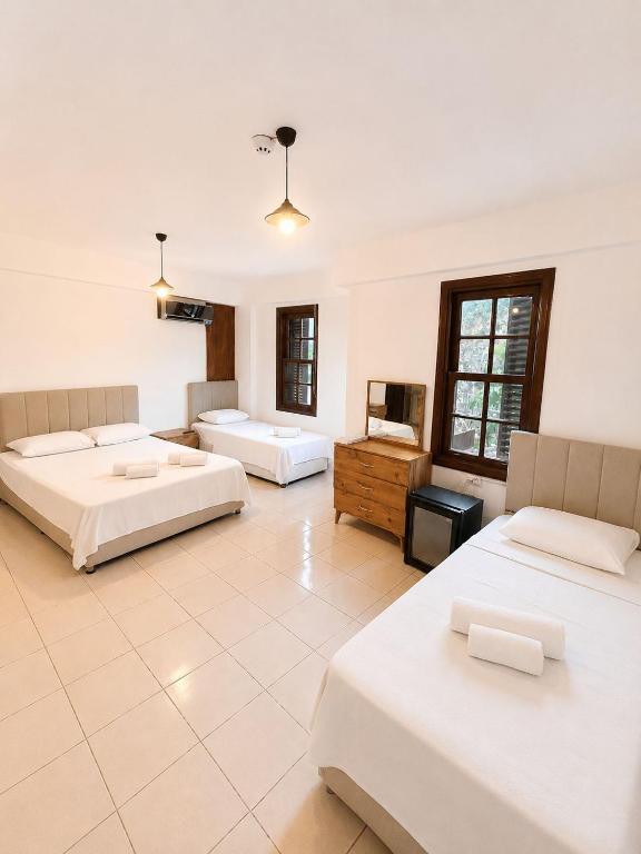 a large room with three beds and a television at White City Pension in Antalya