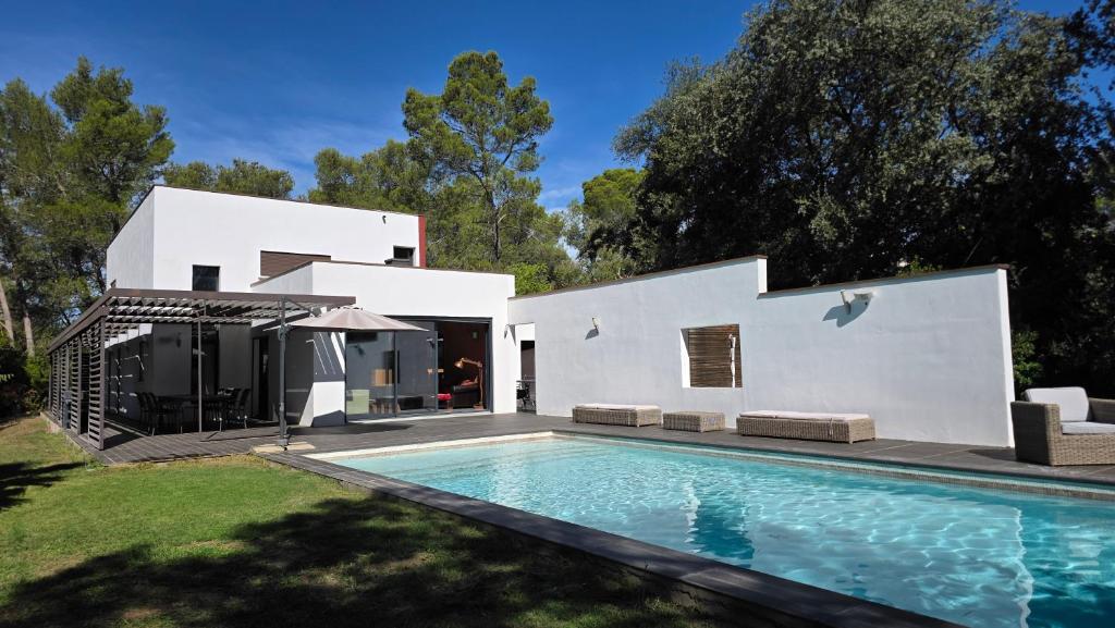 a white house with a swimming pool in the yard at villa d'engance et ses dépendances in Nîmes