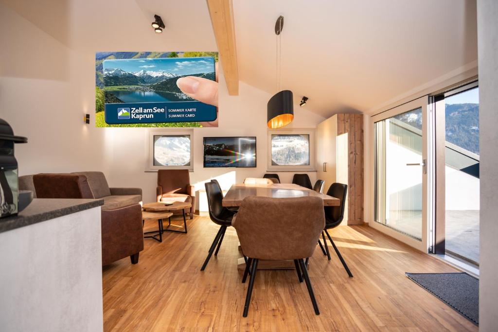 a dining room with a table and chairs at Appartementhaus AURUM - Summercard included in Zell am See