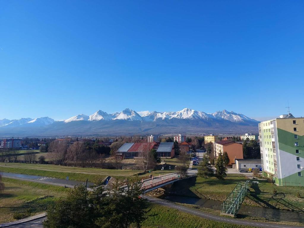 a city with a bridge and mountains in the background at Apartmán 504 Svit in Jezersko
