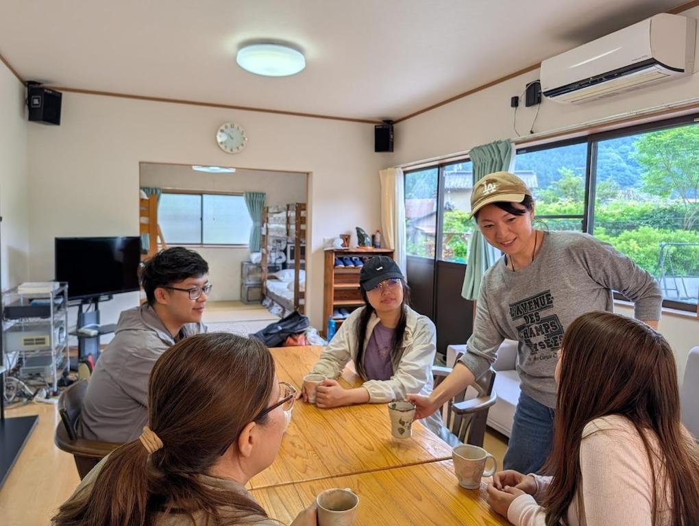 a group of people sitting around a table at 平屋宿まえの in Motoyama