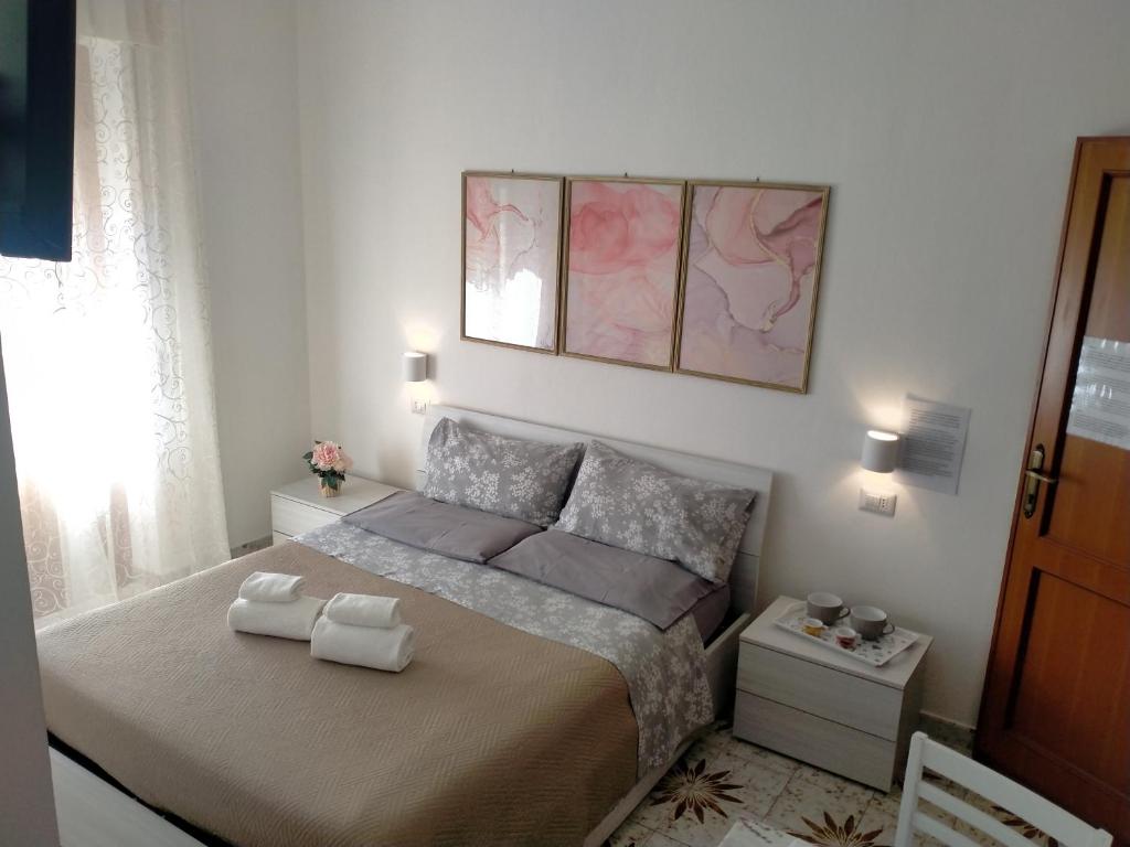 a bedroom with a bed with two towels on it at Le Camelie camera in Bosa