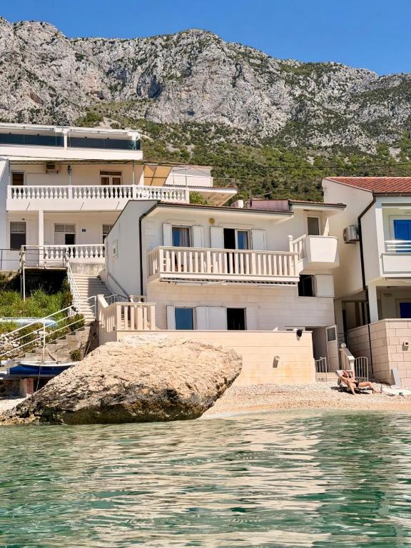 a house on the beach with a rock in the water at Villa Ocean Breeze First Row in Brist